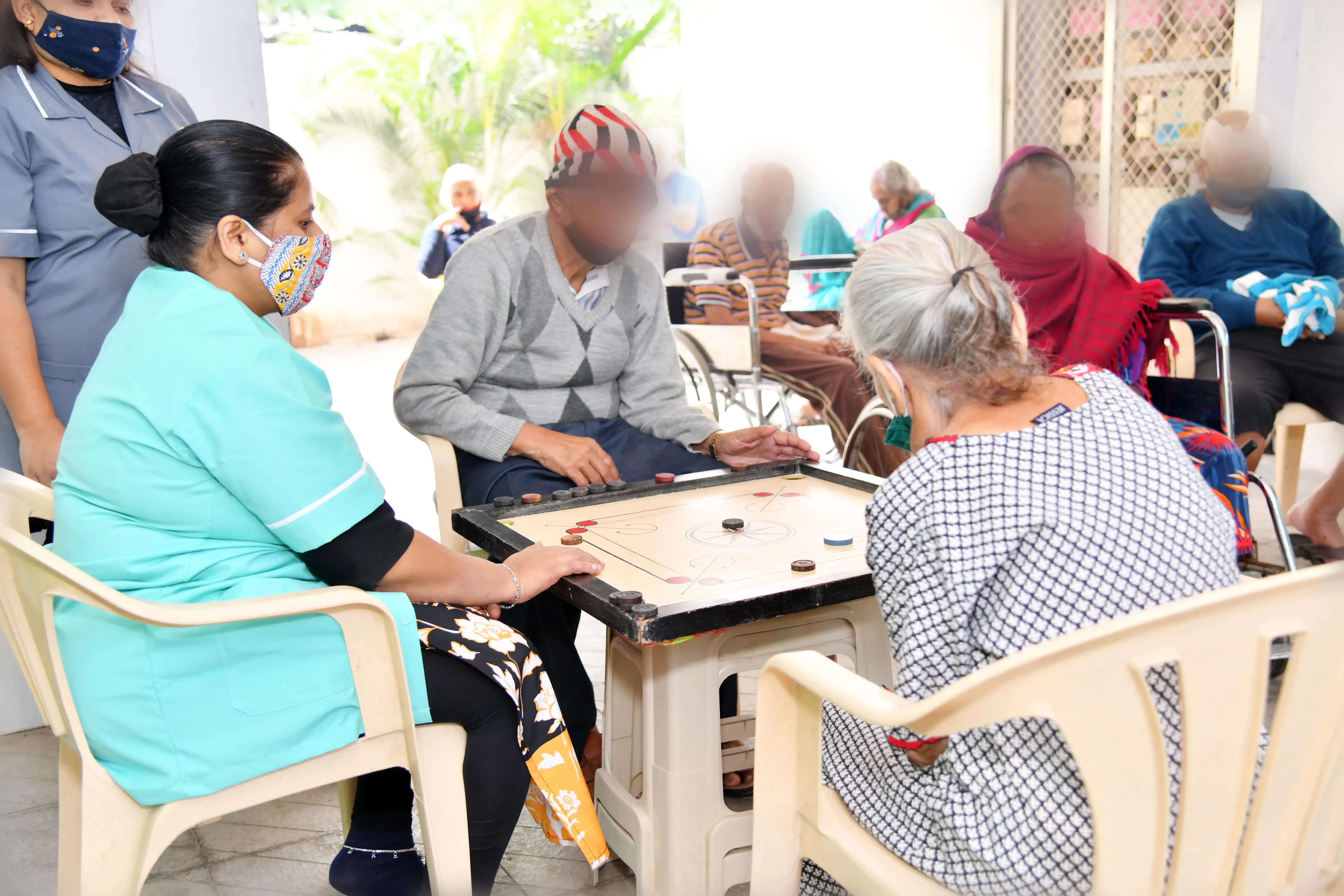 A carer playing carrom with residents