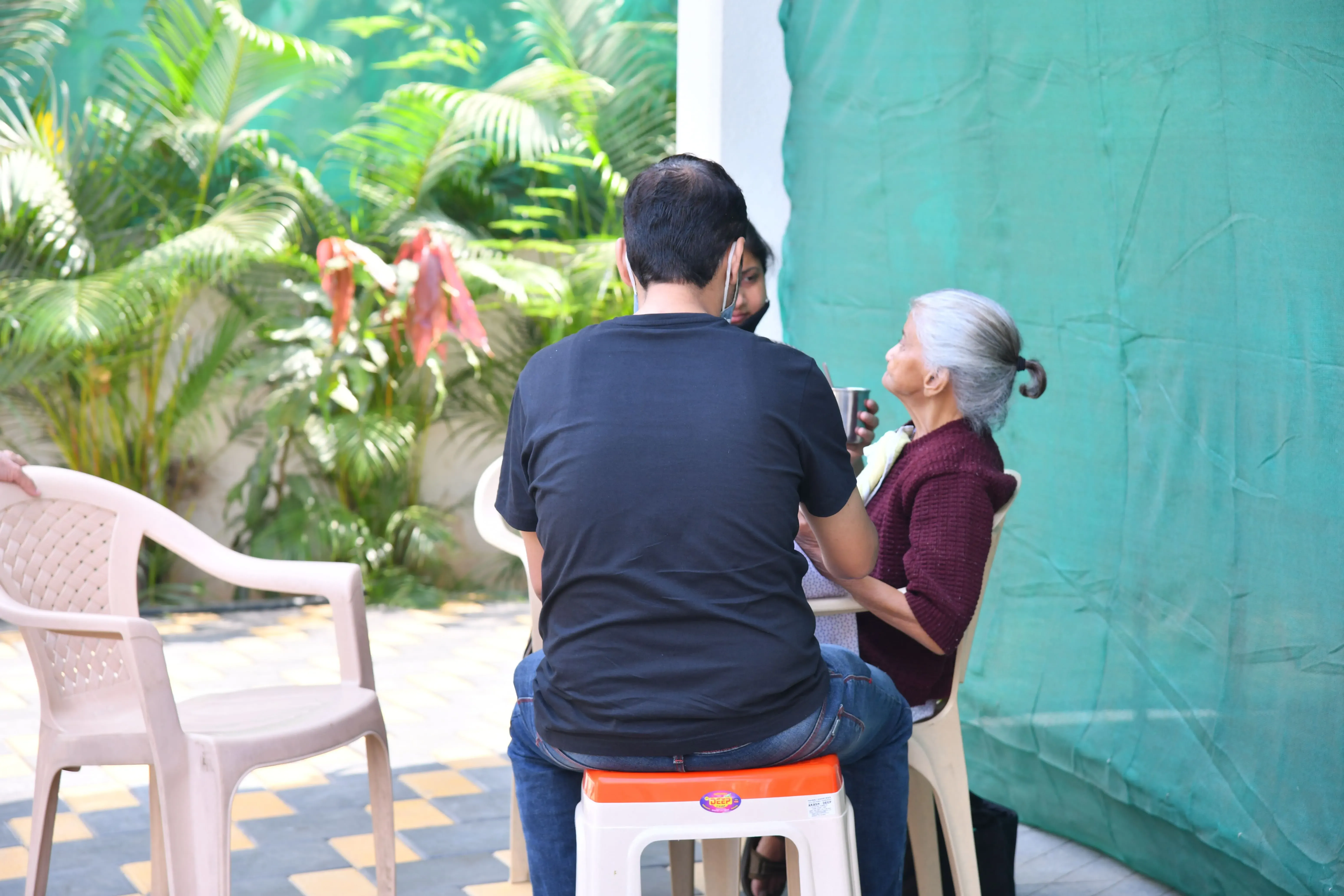 A resident having tea with a visitor in the garden